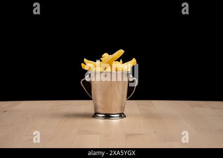 Ein silberner Eimer Pommes Frites auf einem Tisch Stockfoto