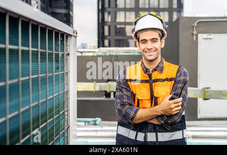 Ein glücklicher Bauarbeiter in orangefarbener Sicherheitsausrüstung und Schutzhelm auf einer Baustelle in Thailand, Bangkok Stockfoto