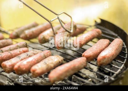 Eine Nahaufnahme von Würstchen, die auf einem Grill grillen Stockfoto