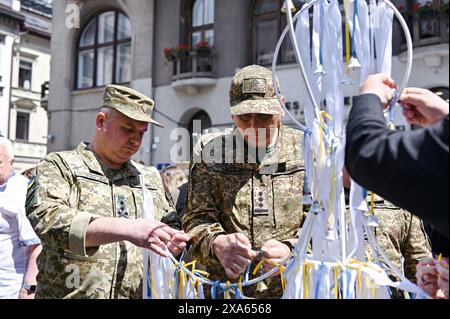 LEMBERG, UKRAINE – 04. JUNI, 2024: die Soldaten nehmen an der Kampagne „Children’s Voices“ Teil, die am Tag des Gedenkens an die Kinder organisiert wird, die infolge der bewaffneten Aggression der Russischen Föderation gegen die Ukraine auf dem Ploschcha Anheliv Platz in der Nähe der Garnisonkirche der Heiligen Apostel Peter und Paulus von der starben UGCC, Lemberg, Westukraine Stockfoto