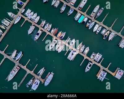 Ein Blick aus der Vogelperspektive auf einen bezaubernden Yachthafen mit aneinandergereihten Booten und Yachten entlang des Ufers Stockfoto