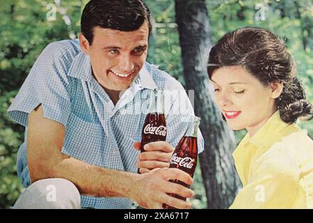 Viersen, Deutschland - 9. Mai. 2024: Das alte us-amerikanische Retro-Magazin Coca Cola, das 1965 mit einem jungen Flirtpaar im Park wirbt Stockfoto