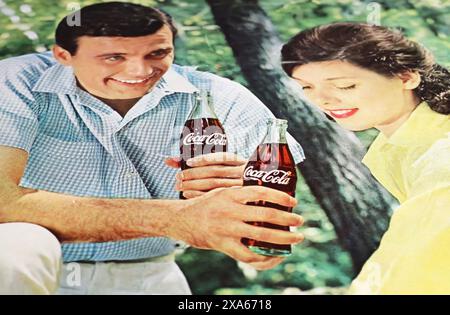 Viersen, Deutschland - 9. Mai. 2024: Das alte us-amerikanische Retro-Magazin Coca Cola, das 1965 mit einem jungen Flirtpaar im Park wirbt Stockfoto