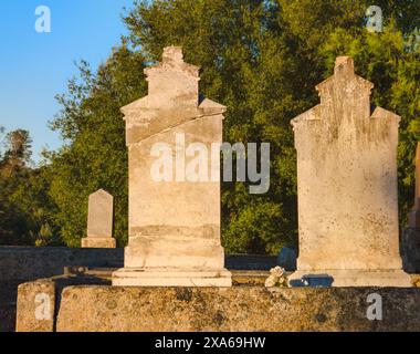 Die alten Steingrabsteine, die auf einem Friedhof ausgerichtet sind Stockfoto