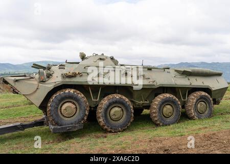 Russischer Panzerträger BTR-80 in grüner Tarnung an einem Traktor befestigt Stockfoto