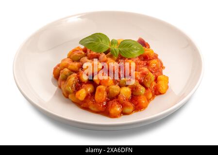 Kartoffelknödel mit Tomatensauce und Basilikumblättern in weißer Platte isoliert auf weiß mit Schnittpfad enthalten Stockfoto