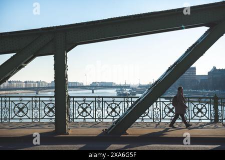 Budapest, Ungarn - 07. Januar 2019: Silhouette einer Person, die am frühen Morgen über eine Freiheitsbrücke spaziert Stockfoto