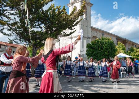 Lania, Limassol District, Zypern - 13. Mai 2023: Dorfbewohner in Volkstrachten führen in der Nähe einer alten Kirche einen traditionellen Tanz auf, um die Einheimischen zu feiern Stockfoto