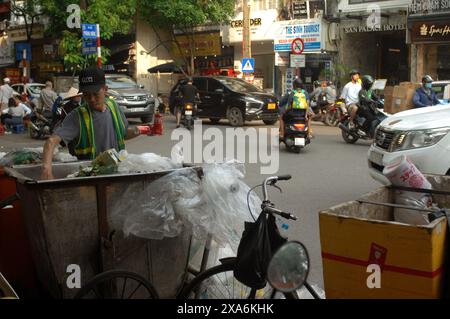 Müllsammler recyceln Dosen und Flaschen aus einem Abfalleimer auf den Straßen von Hanoi, Vietnam. Stockfoto