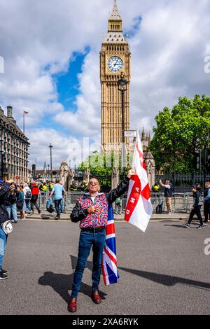 Ein Mann, der ein Union Jack Kostüm trägt, schwingt vor Big Ben ein englisches Kreuz der St. George Flagge nach einer Kundgebung gegen Two Tier Poliing, London, Großbritannien. Stockfoto