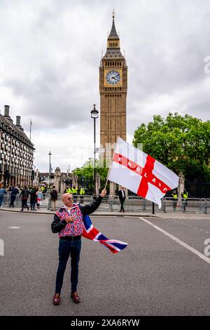 Ein Mann, der ein Union Jack Kostüm trägt, schwingt vor Big Ben ein englisches Kreuz der St. George Flagge nach einer Kundgebung gegen Two Tier Poliing, London, Großbritannien. Stockfoto