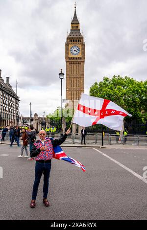 Ein Mann, der ein Union Jack Kostüm trägt, schwingt vor Big Ben ein englisches Kreuz der St. George Flagge nach einer Kundgebung gegen Two Tier Poliing, London, Großbritannien. Stockfoto