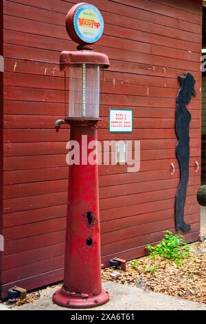 Alte rote Gaspumpe mit Hydrant neben Ziegelwand Stockfoto