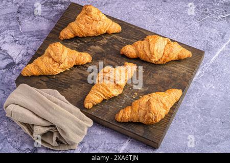 Ein Blick von oben auf Croissants auf einem hölzernen Schneidebrett Stockfoto