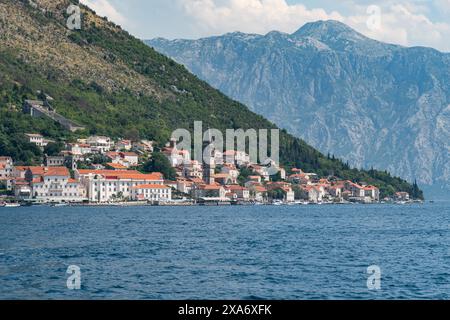 Die malerische kleine Stadt Perast liegt am Ufer der Kotor Bay, umgeben von atemberaubenden Bergen, Montenegro Stockfoto