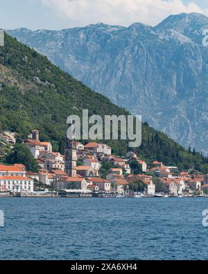 Die malerische kleine Stadt Perast liegt am Ufer der Kotor Bay, umgeben von atemberaubenden Bergen, Montenegro Stockfoto