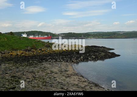 Ein großes Frachtschiff, das den Fluss entlang fährt Stockfoto