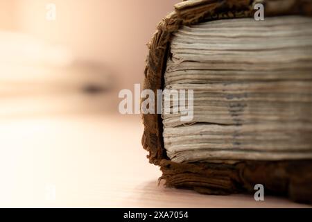 Eine Nahaufnahme des Buchrückens und der Seiten eines alten, ausgefransten Buches, die seine verwitterte Textur und sein Alter zeigen. Stockfoto