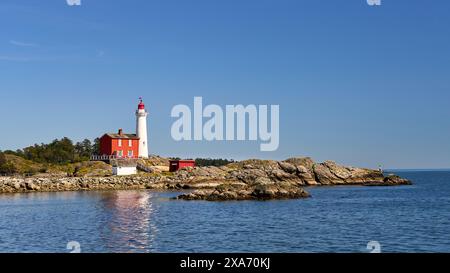 Blick auf den historischen Fisgard Lighthouse und das umliegende blaue Meer. Stockfoto