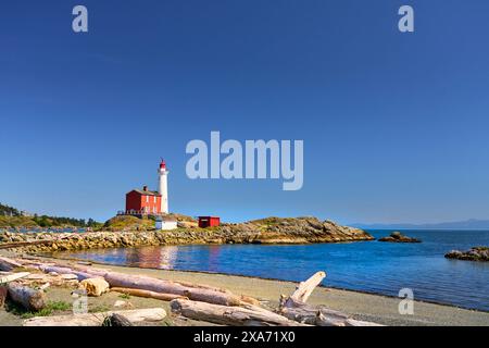 Blick vom Strand auf den restaurierten historischen Fisgard Lighthouse, eine beliebte Touristenattraktion. Stockfoto