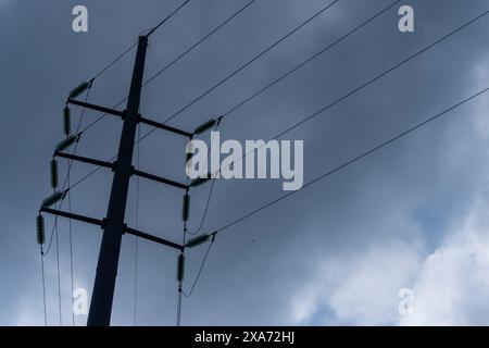 Die Silhouette des Elektromasts vor dem dramatisch bewölkten Himmel Stockfoto