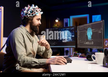 Mann, der EEG-Headset verwendet, um mit künstlicher Intelligenz auf dem Computer in Binärcode zu kommunizieren. Programmierer sendet Gehirnwellen-Signale an KI-Einheit auf dem PC mithilfe eines High-Tech-Geräts Stockfoto