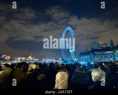 Die Menge versammelt sich, um zu sehen, wie ein Feuerwerk den Londoner Himmel erleuchtet Stockfoto