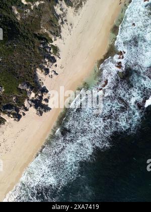 Aus der Vogelperspektive auf Wellen, die an einem Sandstrand zusammenbrechen Stockfoto