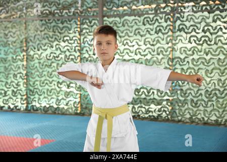 Junge im Kimono, der Karate im Outdoor-Fitnessstudio übt Stockfoto