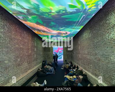 Gruppe von Personen, die sich Videowandprojektionen anschauen Stockfoto