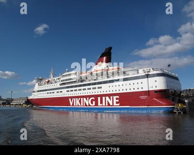 Ein großes Boot mit weißen, roten und blauen Segeln auf dem Wasser Stockfoto