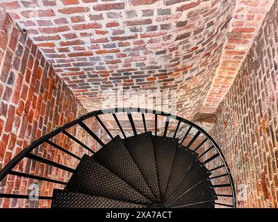 Nahaufnahme des schwarzen, schmiedeeisernen Treppengeländes, umgeben von roten Ziegelmauern am Fisgard Lighthouse, Victoria, BC. Stockfoto