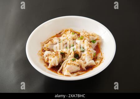 Eine Nahaufnahme von Ravioli in einer Schüssel auf einem schwarzen Tisch Stockfoto