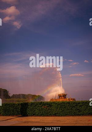 Ein Brunnen im Park, der Wasser in den Himmel schießt und einen Regenbogen erzeugt Stockfoto