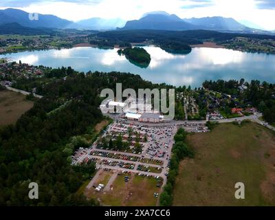 Blick aus der Vogelperspektive auf See, Wald und Berge mit Autos, die auf dem Gehweg geparkt sind Stockfoto