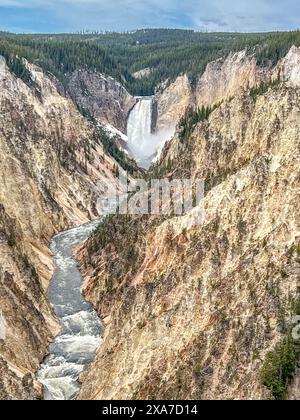 Ein Fluss fließt durch einen Canyon unter einer Klippe Stockfoto