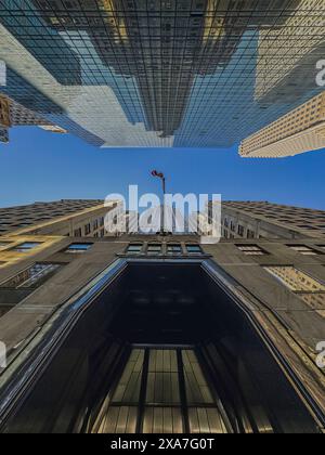 Ein hohes städtisches Gebäude, das von unten gefangen wurde und die amerikanische Flagge in der Luft schwingt Stockfoto