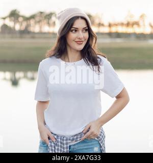 Frau am See in weißem Hemd und Jeans Stockfoto