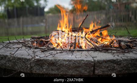 Kreisförmige Feuerstelle, umgeben von Feuerholz und Feuerholz Stockfoto