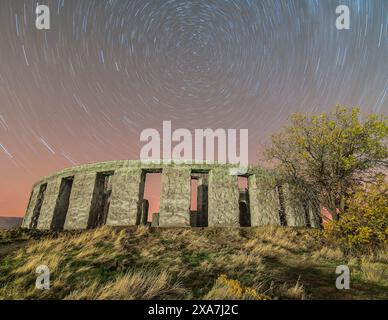 Sternenpfade über dem antiken Steindenkmal vor dem Nachthimmel Stockfoto