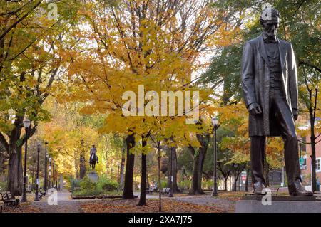 Eine Statue von Abraham Lincoln im Mantel, in einem Fallpark Stockfoto