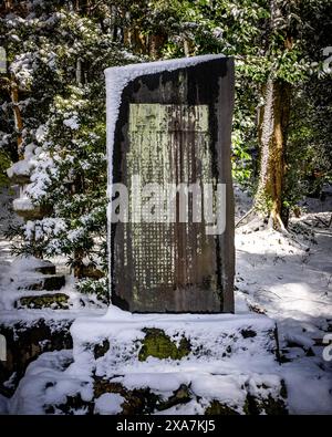 Ein traditionelles japanisches Steindenkmal im antiken Stil, bedeckt mit seltenem Winterschnee am Fushimi Inari Schrein in Kyoto Japan. Stockfoto