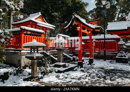 Ein altes traditionelles japanisches Tor und Tempel bedeckt mit seltenem Winterschnee am Fushimi Inari Schrein in Kyoto Japan. Stockfoto