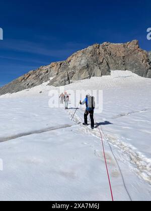 Zwei Wanderer auf schneebedeckten Berghängen mit Stangen in den französischen Alpen Stockfoto