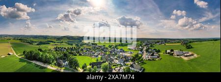 Luftpanorama des Landkreises Wuelfte bei Brilon im Sauerland. Häuser, Felder, Bauernhöfe und eine Kapelle vor grünen Hügeln. Blauer Himmel. Deutschland Stockfoto