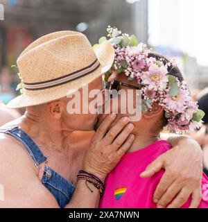 Ein LGBT-Paar in Vibrant teilt einen Kuss auf dem unscharfen Hintergrund Stockfoto