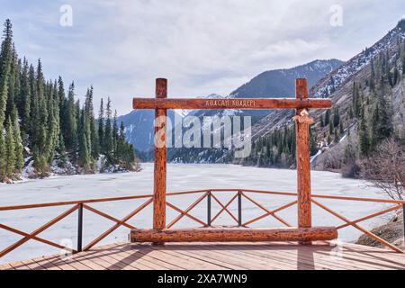 Touristische Fotozone und Aussichtsplattform. Malerischer See, bedeckt mit Eis, umgeben von grünen Hügeln. Nördlicher Tien Shan, Kolsai-Schlucht, Kasachisch Stockfoto