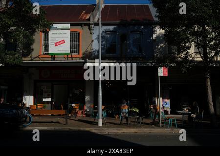 Eine Reihe von Terrassengeschäften, Cafés mit Stühlen und Tischen auf dem Fußweg in der Abercrombie St Chippendale, Sydney, New South Wales Stockfoto