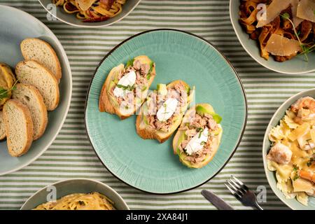 Leckere Thunfisch-Bruschettas mit Weichkäse auf Teller am Tisch. Stockfoto