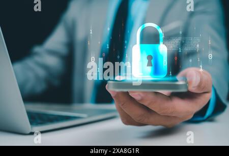 Geschäftsmann, der online am Telefon und Computer arbeitet und Schutzsymbole zeigt, Cyberspionage, repräsentiert den Code-Schutz, das Sicherheitskonzept und die Kommunikation Stockfoto